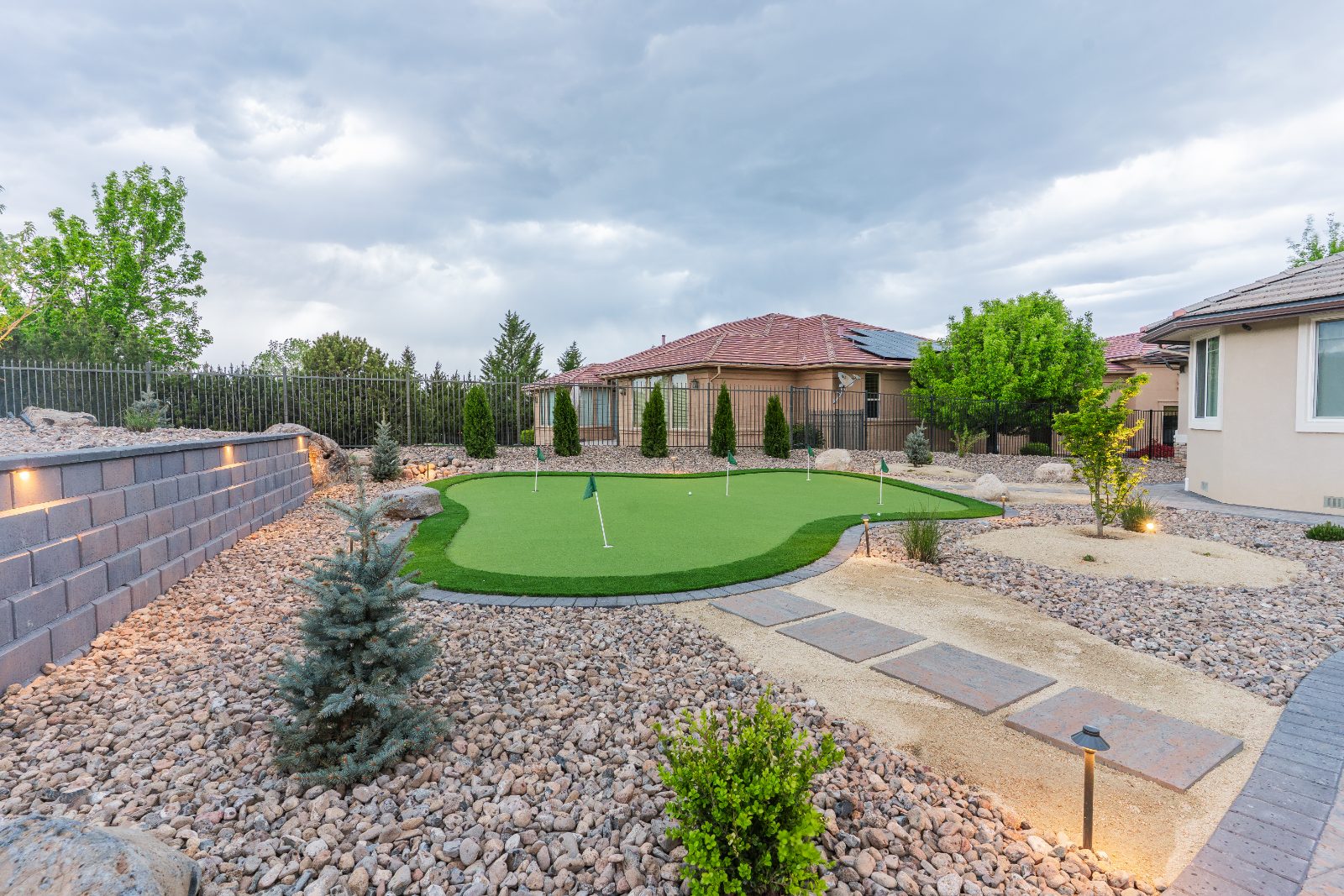 Backyard with a putting green, rock work and paver pathways