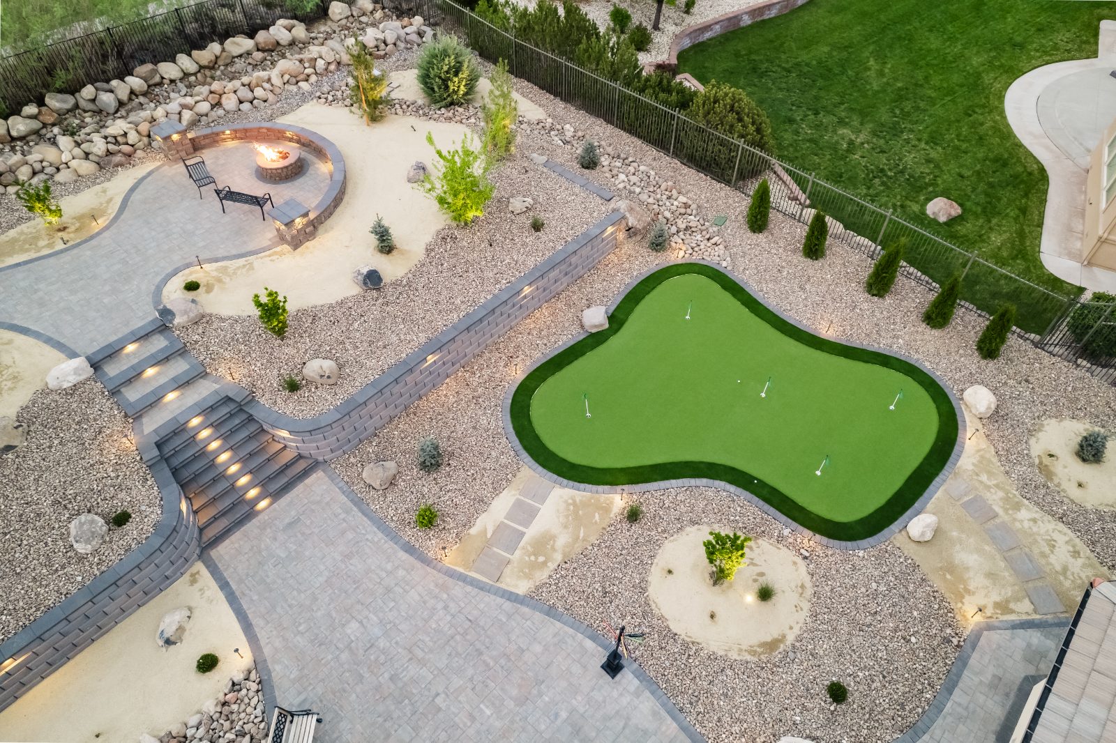 Xeriscape backyard with rock, boulders, a putting green and drought tolerant planting